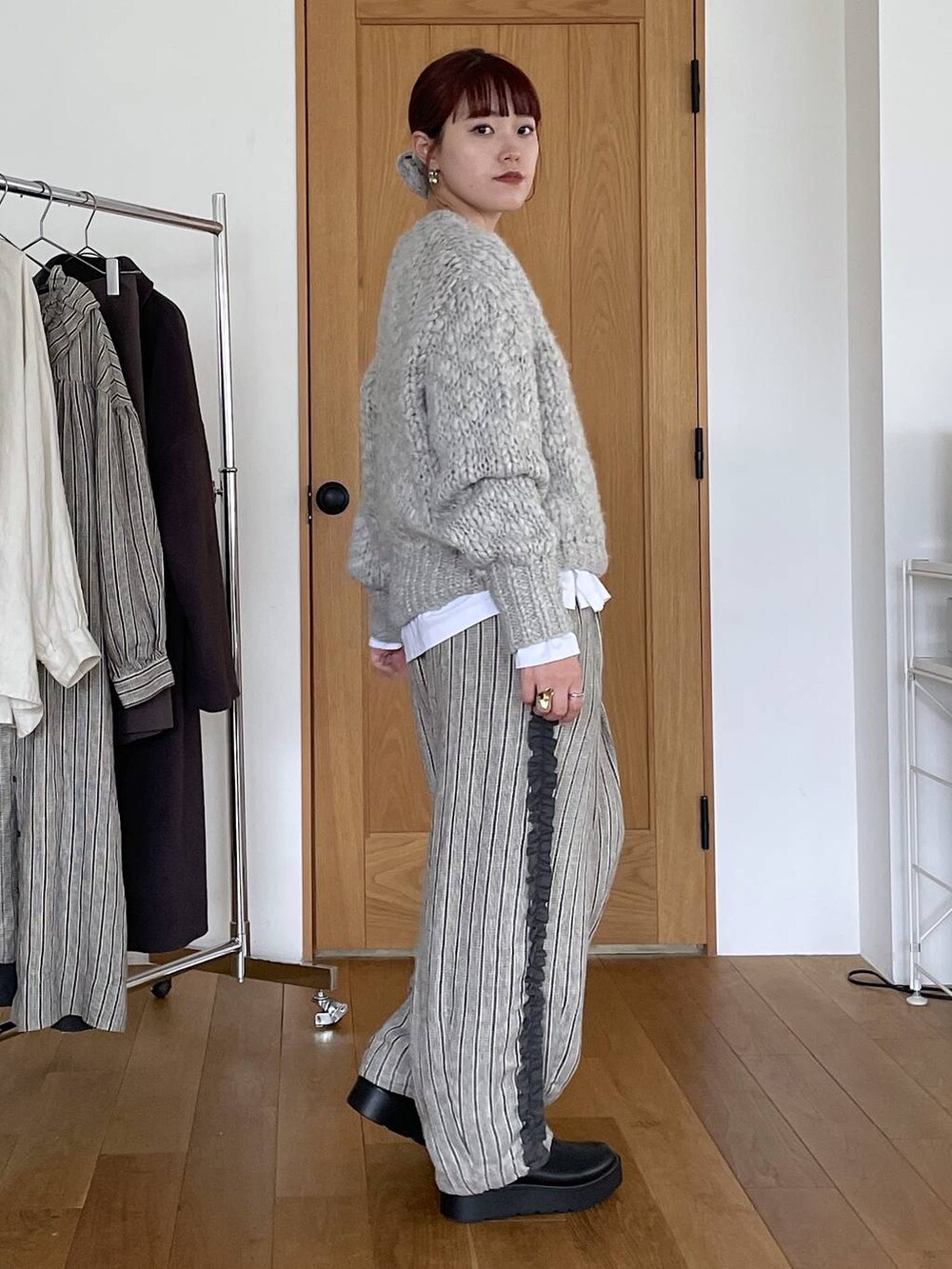 ブラック系のブーツ、その他のTシャツ/カットソー、グレー系のニット/セーターを着用したレディースの秋コーディネートの3枚目の写真