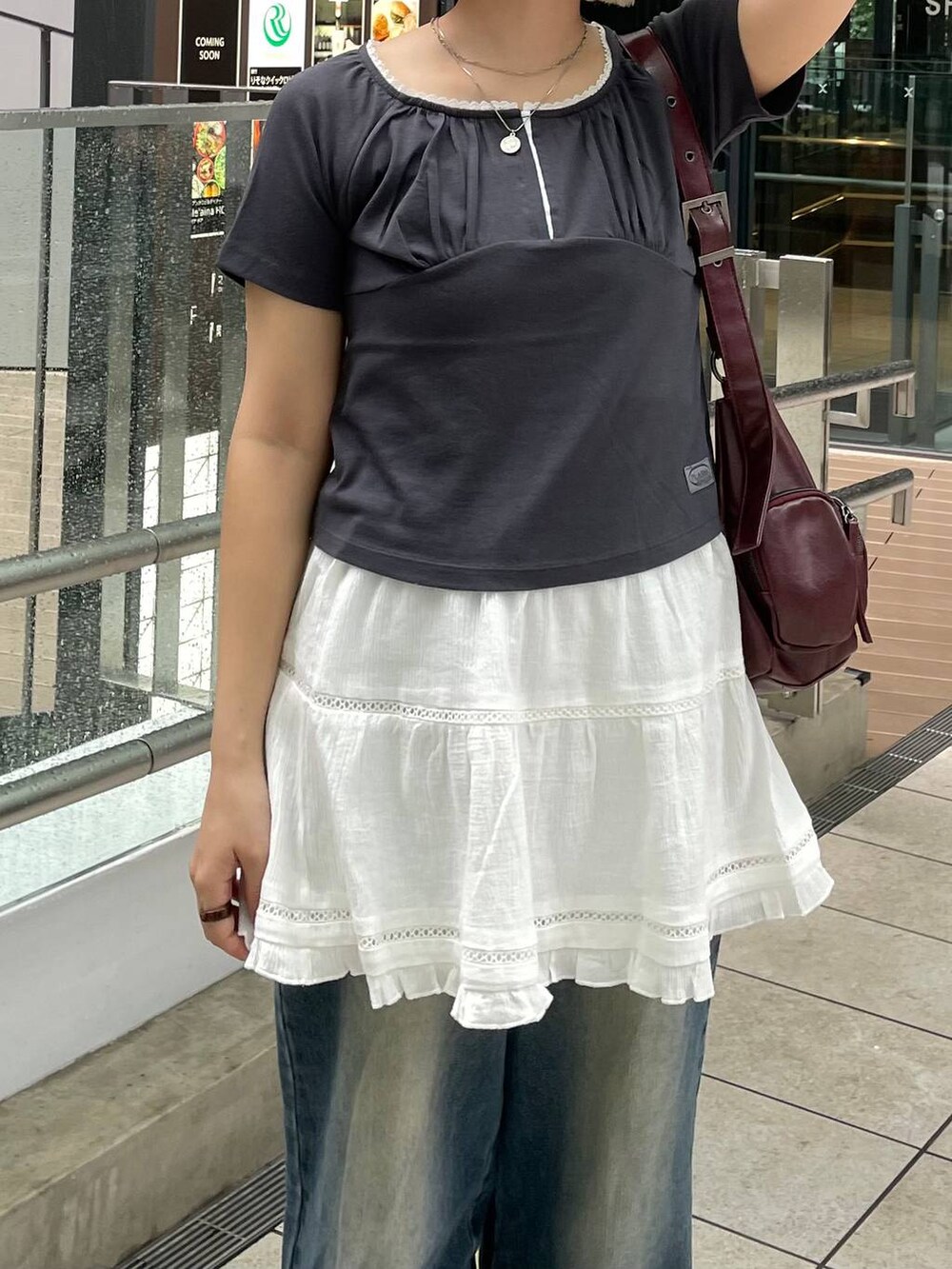 グレー系のTシャツ/カットソー、ホワイト系のスカート、レッド系のショルダーバッグを着用したレディースの秋コーディネートの6枚目の写真