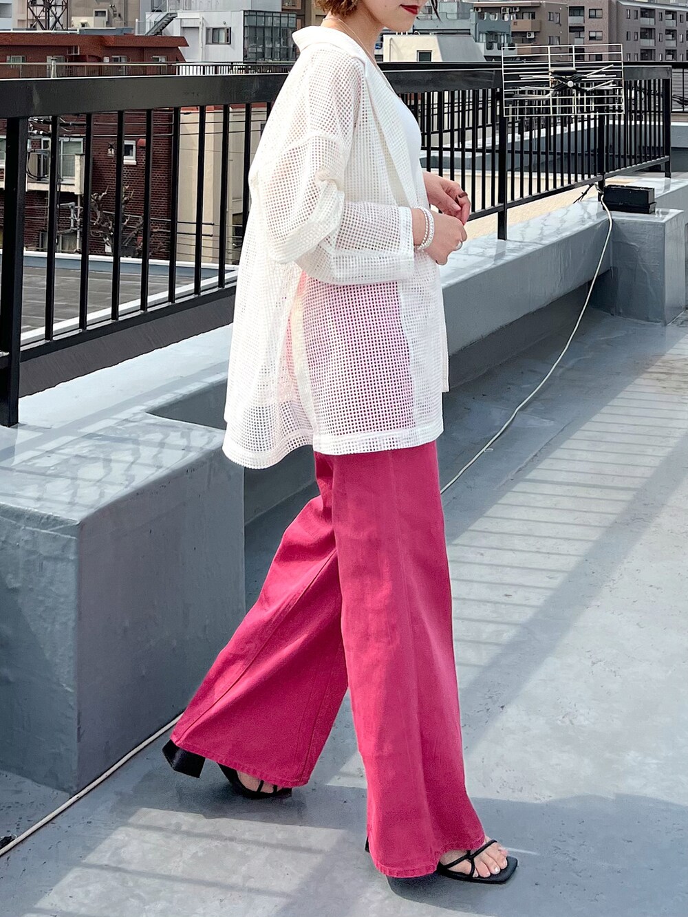 ピンク系のデニムパンツ、ホワイト系のテーラードジャケット、ホワイト系のタンクトップを着用したレディースの春コーディネートの5枚目の写真