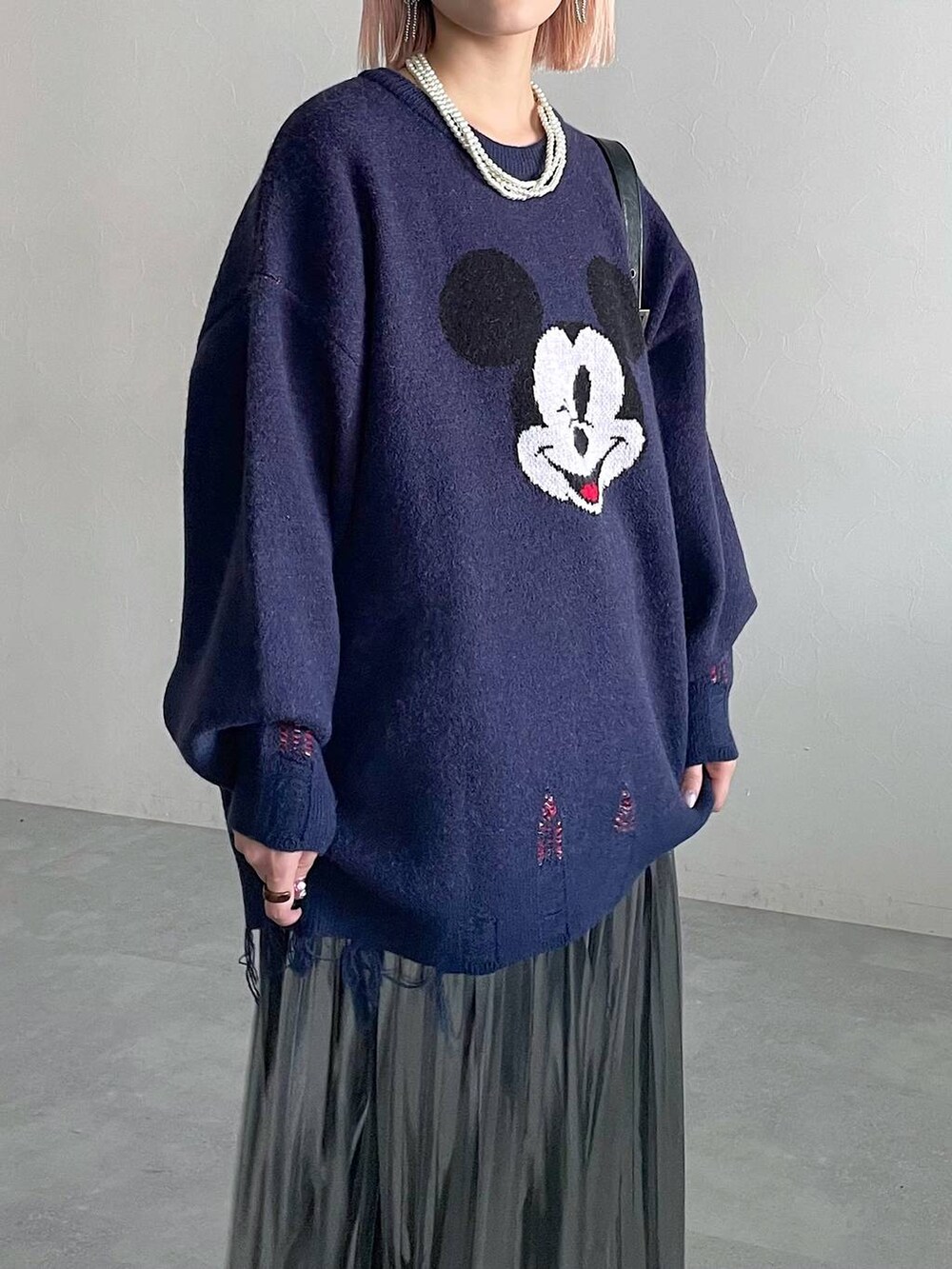 ブラック系のブーツ、ブラック系のショルダーバッグ、グレー系のスカートを着用したレディースの秋コーディネートの2枚目の写真