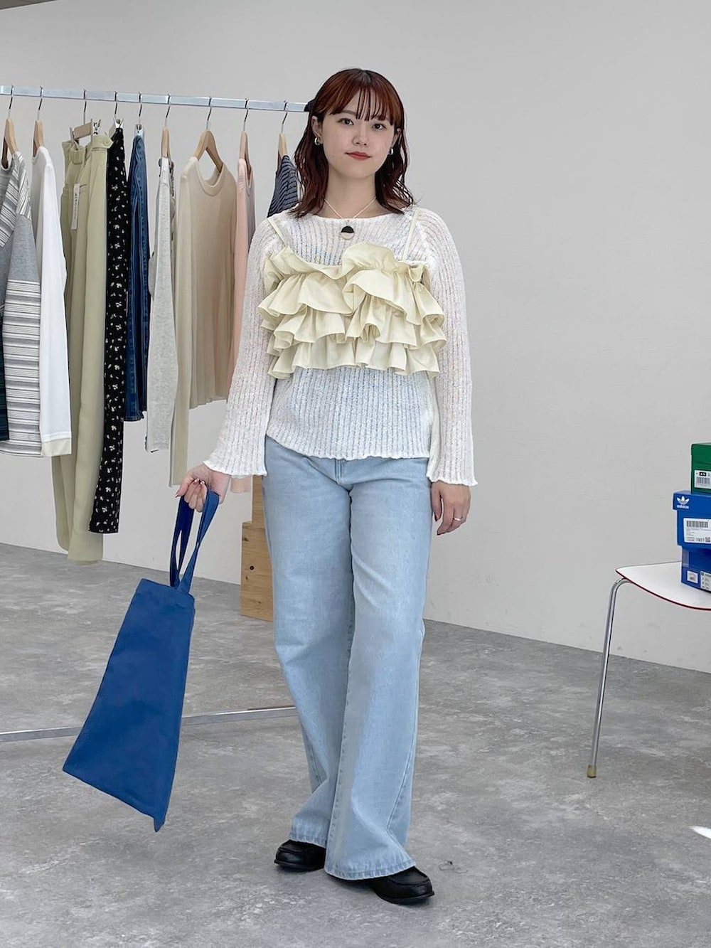 ブラック系のローファー、ブルー系のトートバッグ、ブルー系のデニムパンツを着用したレディースの春コーディネートの7枚目の写真