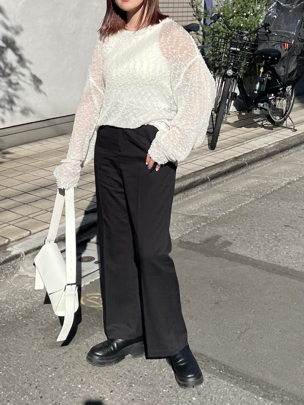 ホワイト系のタンクトップ、ブラック系のスラックス、ホワイト系のバッグを着用したレディースの春コーディネートの4枚目の写真