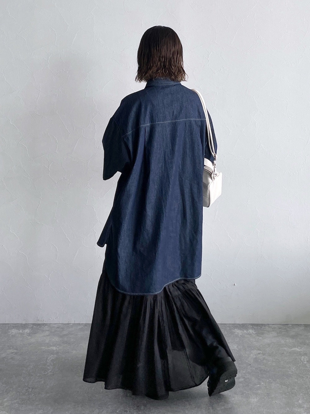 ブルー系のシャツ/ブラウス、ブラック系のスカート、ブラック系のサンダルを着用したレディースの春コーディネートの2枚目の写真