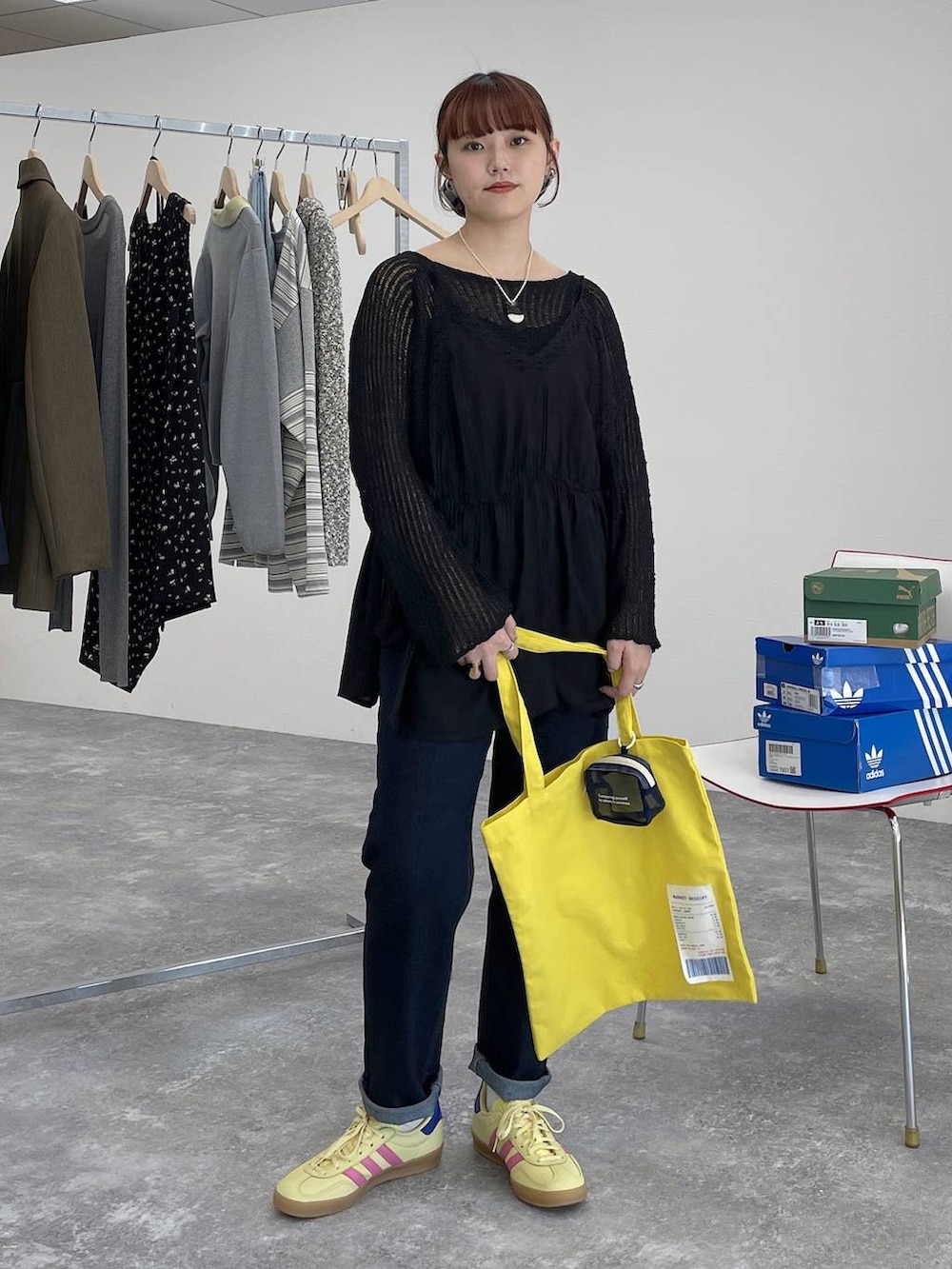 イエロー系のトートバッグ、ブルー系のデニムパンツ、ブラック系のキャミソールを着用したレディースの春コーディネートの5枚目の写真