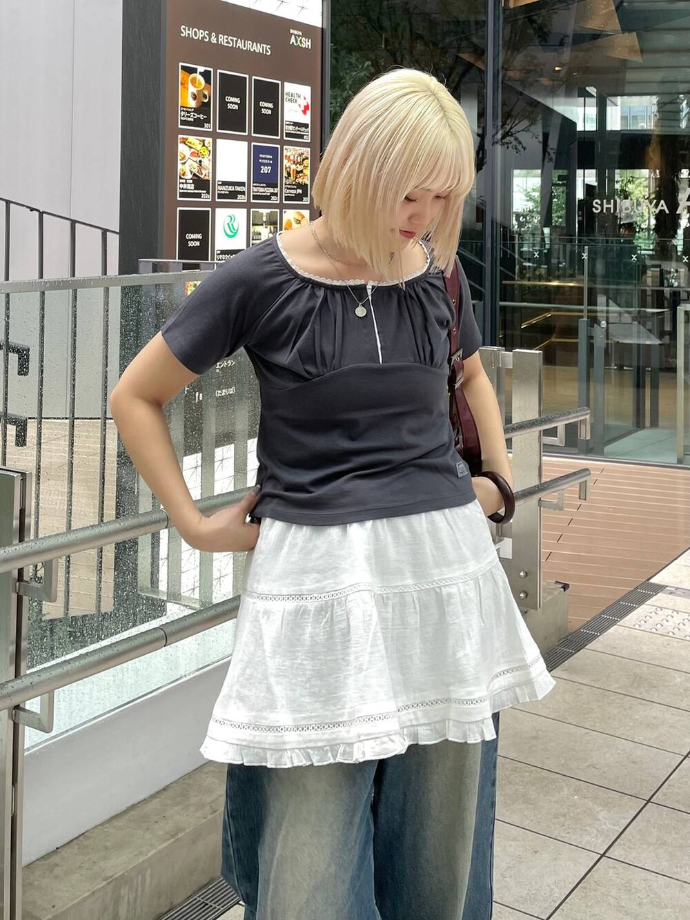グレー系のTシャツ/カットソー、ホワイト系のスカート、レッド系のショルダーバッグを着用したレディースの秋コーディネートの7枚目の写真
