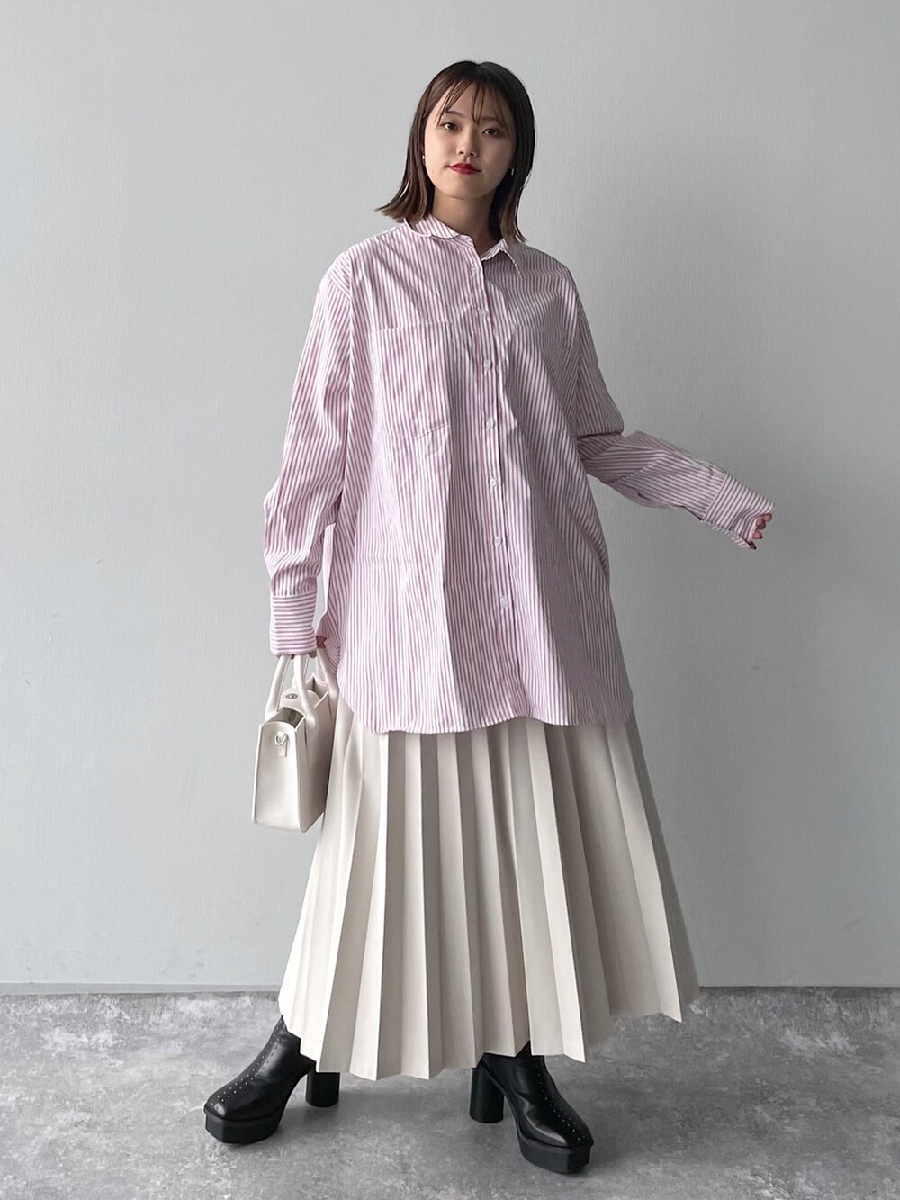 ピンク系のシャツ/ブラウス、ブラック系のバッグ、ホワイト系のスカートを着用したレディースの冬コーディネートの3枚目の写真