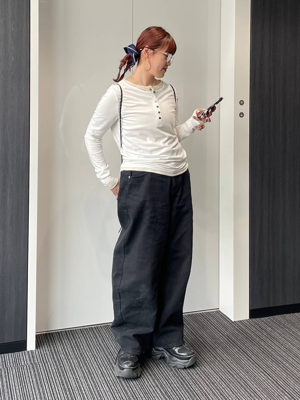 ブラック系のデニムパンツを着用したレディースの春コーディネートの2枚目の写真