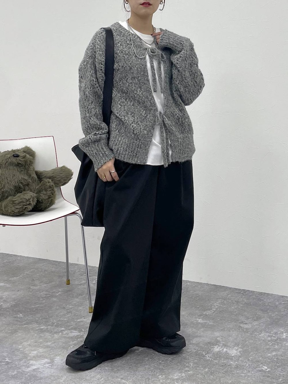 ホワイト系のTシャツ/カットソー、ブラック系のその他パンツ、グレー系のニット/セーターを着用したレディースの秋コーディネートの2枚目の写真