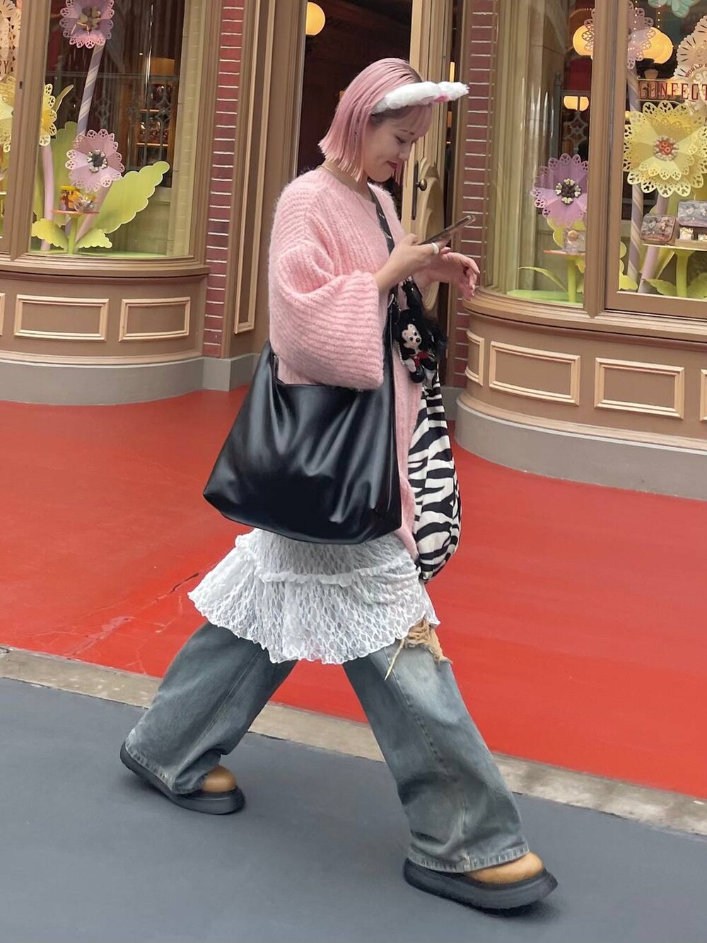 ブルー系のデニムパンツ、ブラック系のボディバッグ/ウエストポーチ、イエロー系のブーツを着用したレディースの秋コーディネートの7枚目の写真