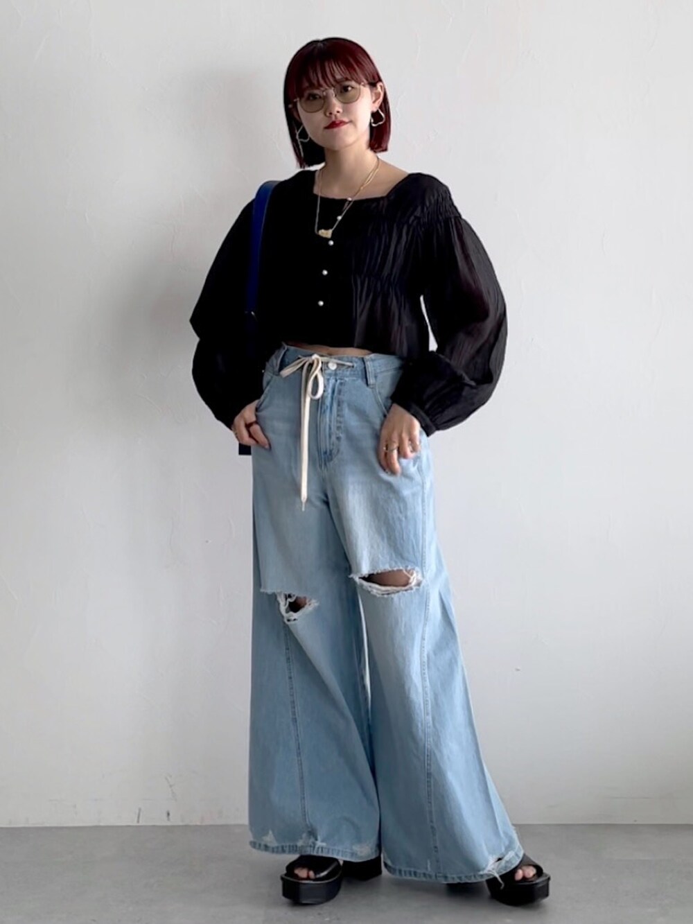 ブルー系のデニムパンツ、ブラック系のシューズ、ブラック系のシャツ/ブラウスを着用したレディースの春コーディネートの6枚目の写真