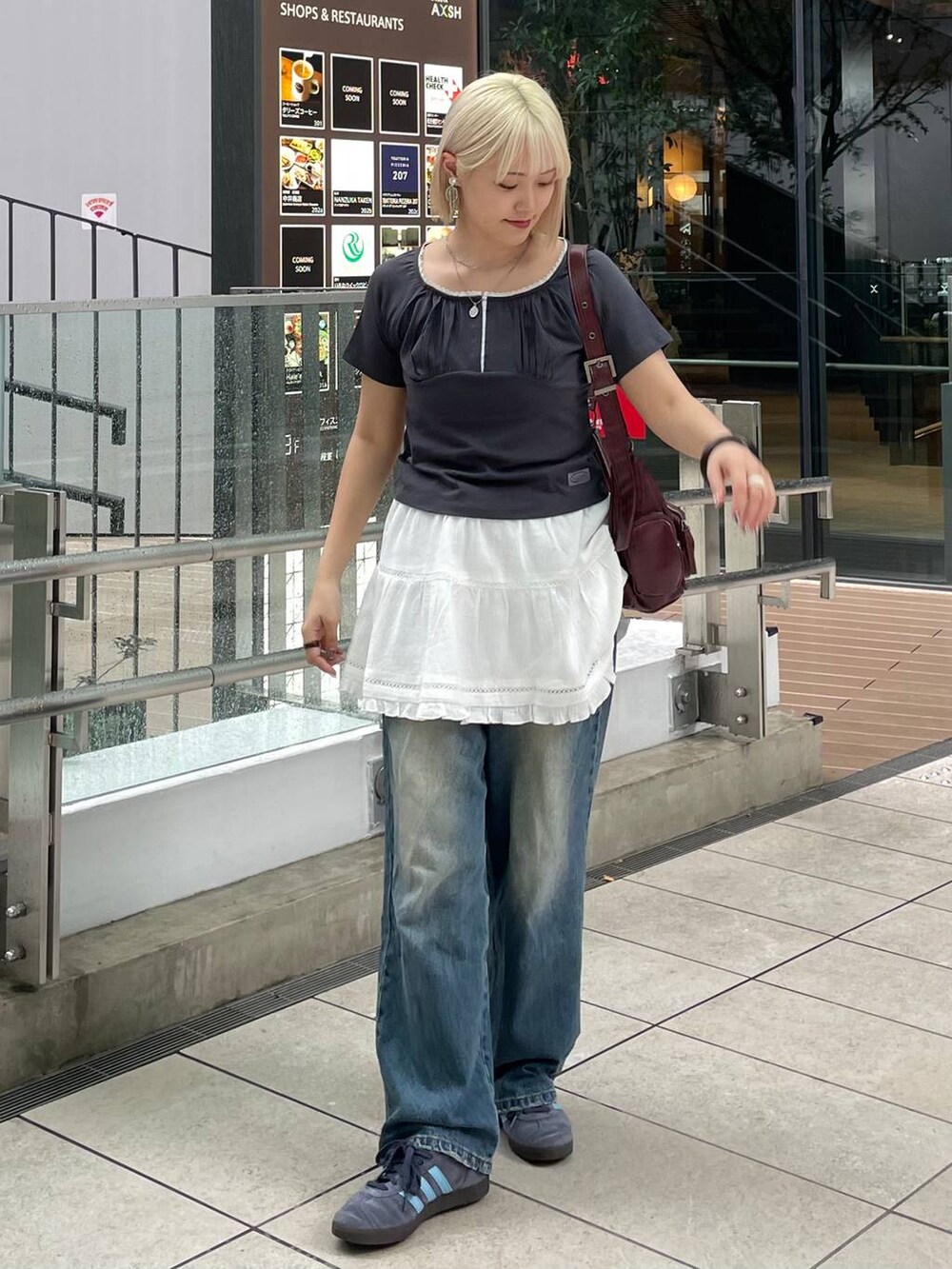 グレー系のTシャツ/カットソー、ホワイト系のスカート、レッド系のショルダーバッグを着用したレディースの秋コーディネートの5枚目の写真