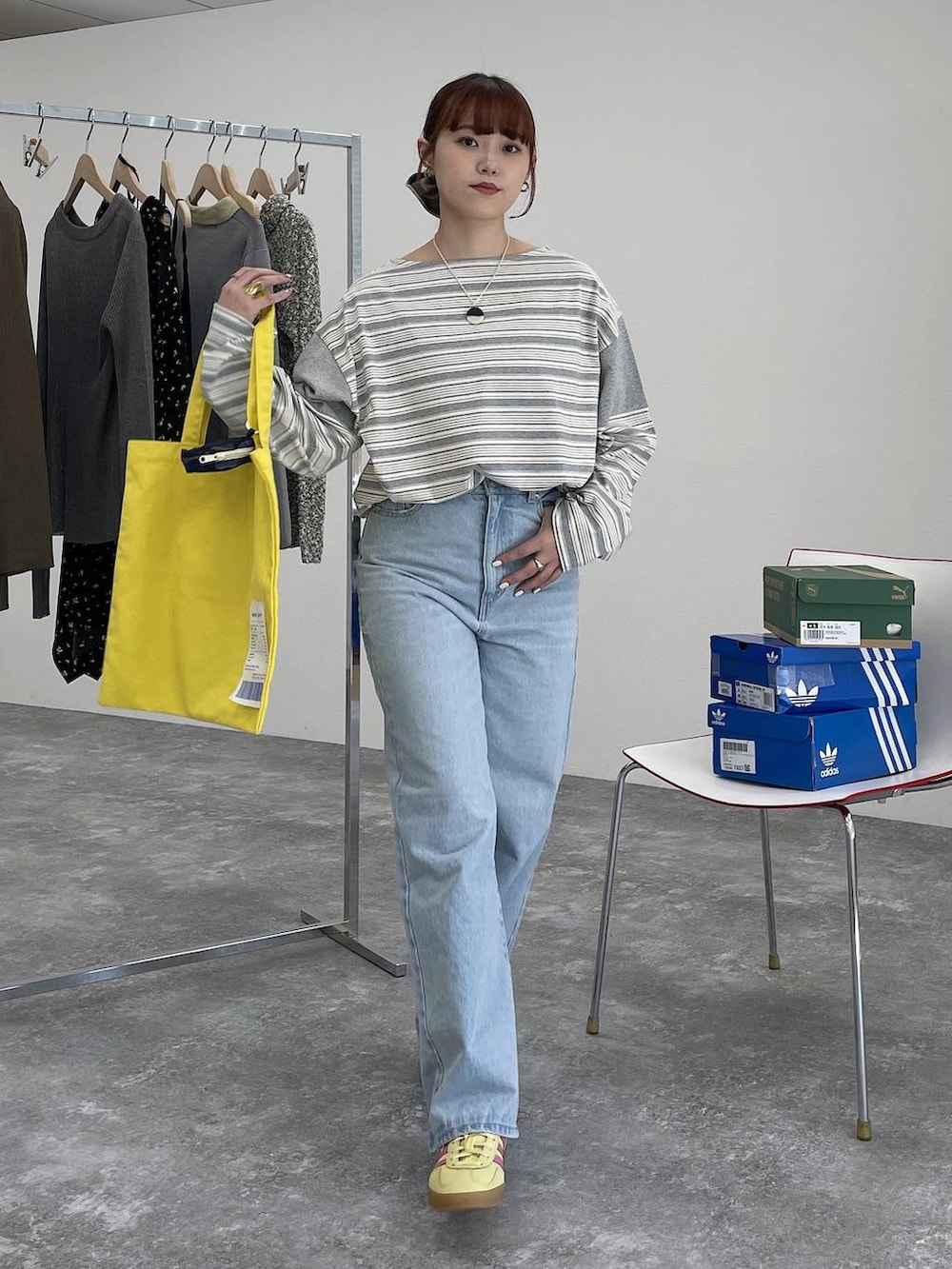 イエロー系のトートバッグ、ブルー系のデニムパンツ、グレー系のTシャツ/カットソーを着用したレディースの冬コーディネートの7枚目の写真