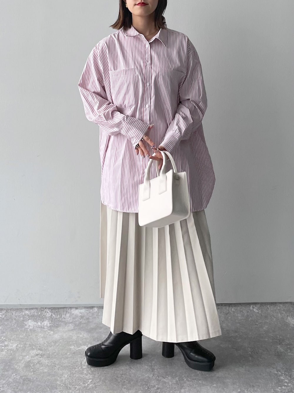 ピンク系のシャツ/ブラウス、ブラック系のバッグ、ホワイト系のスカートを着用したレディースの冬コーディネートの5枚目の写真