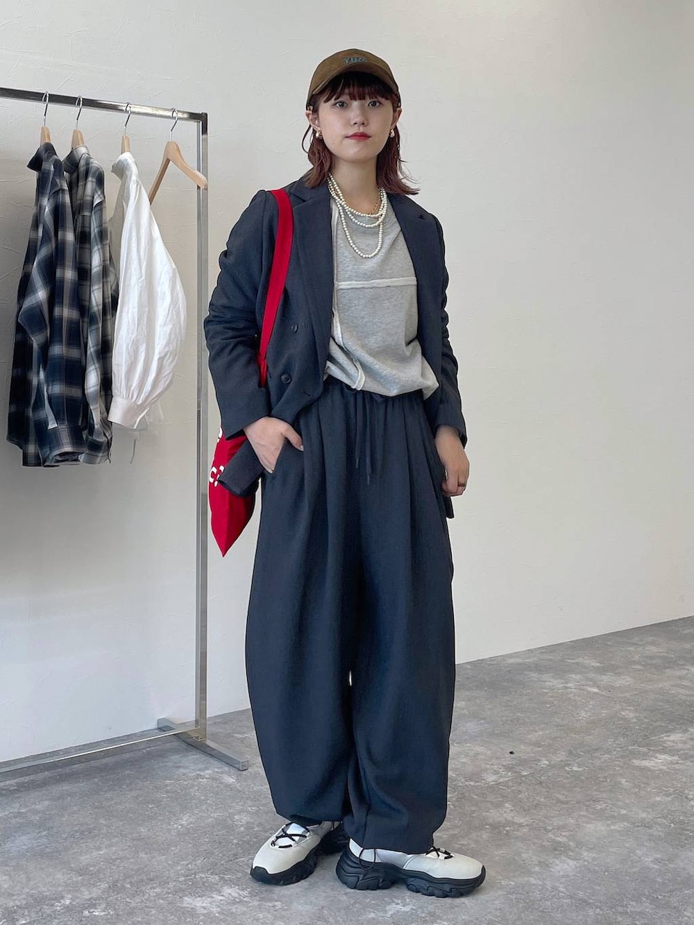グレー系のその他パンツ、グレー系のテーラードジャケット、ホワイト系のスニーカーを着用したレディースの秋コーディネートの6枚目の写真