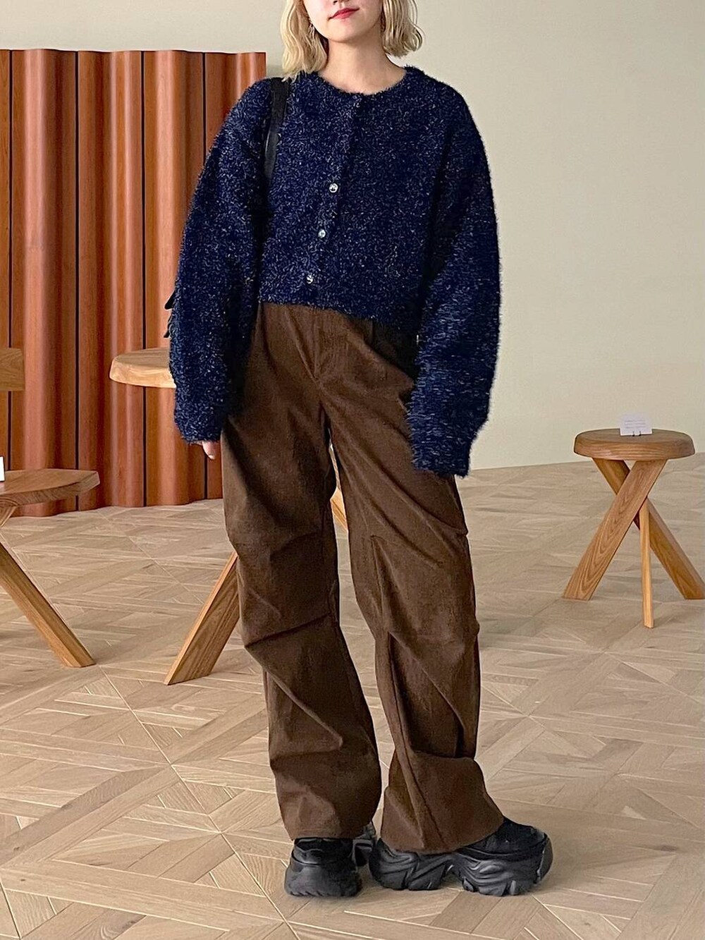 ブラック系のスニーカー、ホワイト系のショルダーバッグ、ブラウン系のその他パンツを着用したレディースの冬コーディネートの2枚目の写真