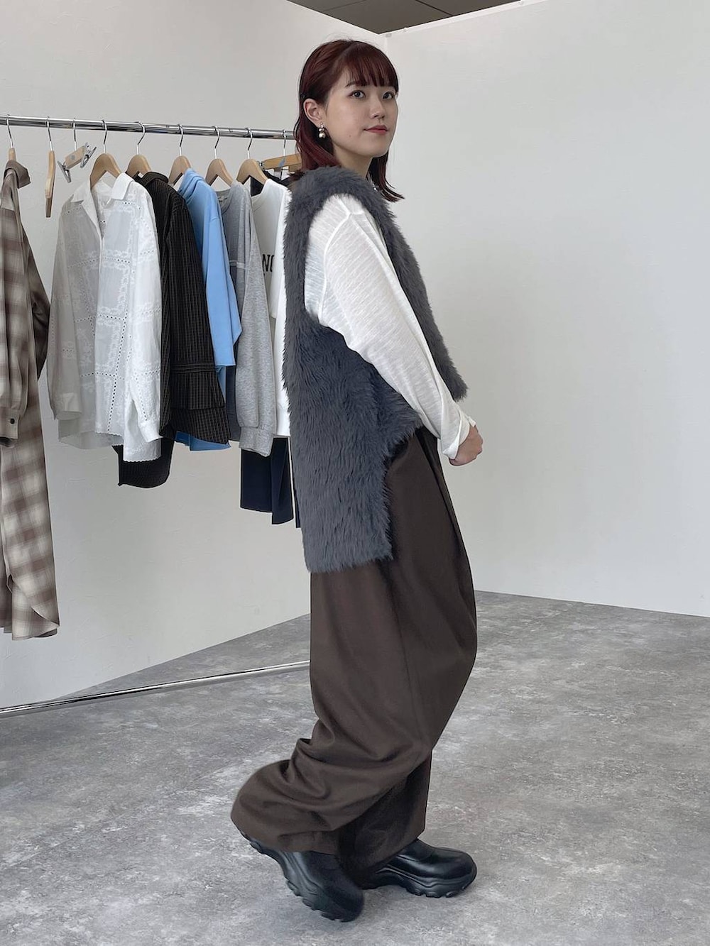 ブラウン系のその他パンツ、ブラック系のブーツ、ホワイト系のTシャツ/カットソーを着用したレディースの秋コーディネートの4枚目の写真