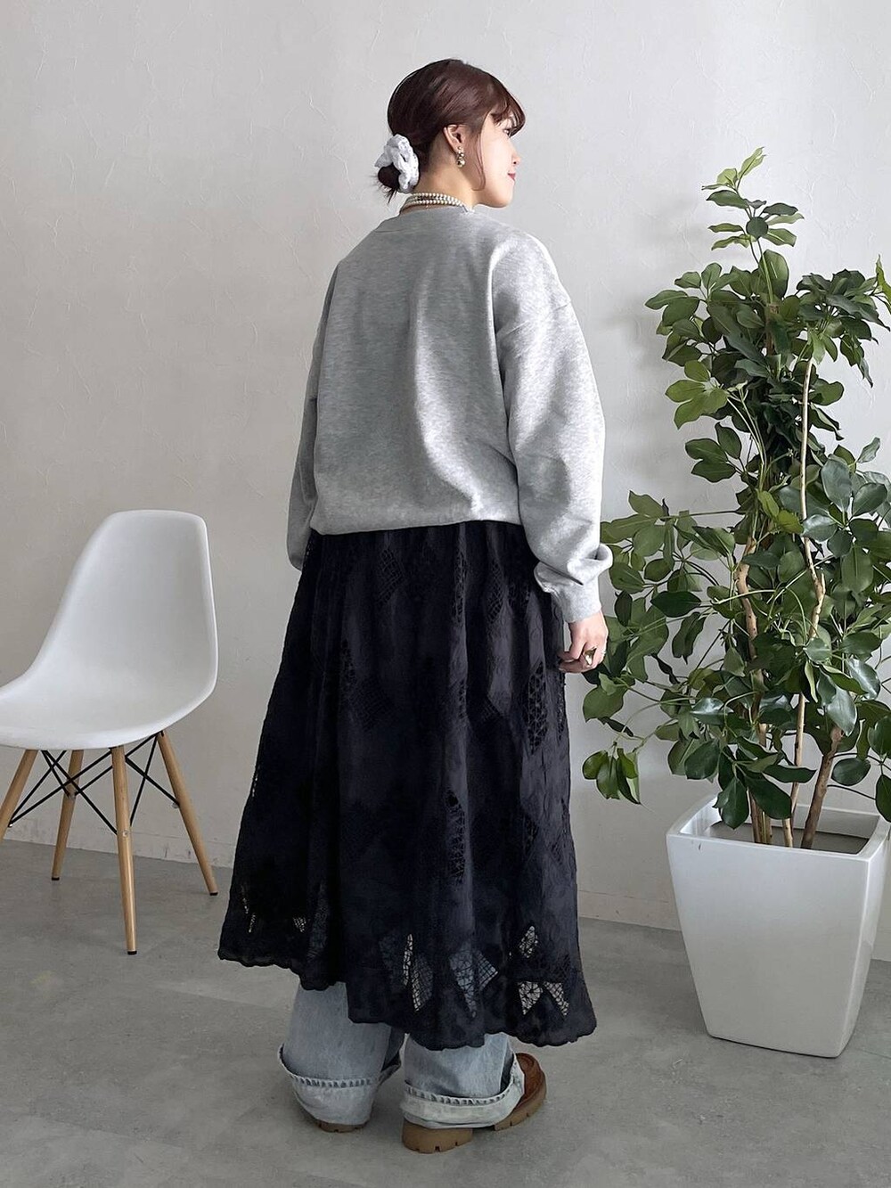 ブルー系のデニムパンツ、ブラック系のスカートを着用したレディースの秋コーディネートの4枚目の写真