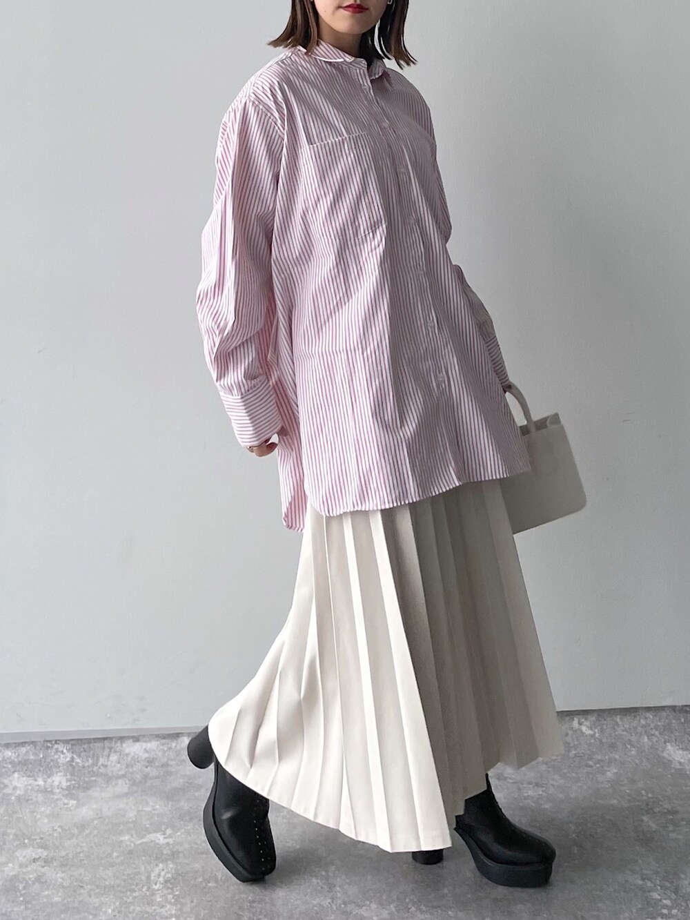 ピンク系のシャツ/ブラウス、ブラック系のバッグ、ホワイト系のスカートを着用したレディースの冬コーディネートの4枚目の写真