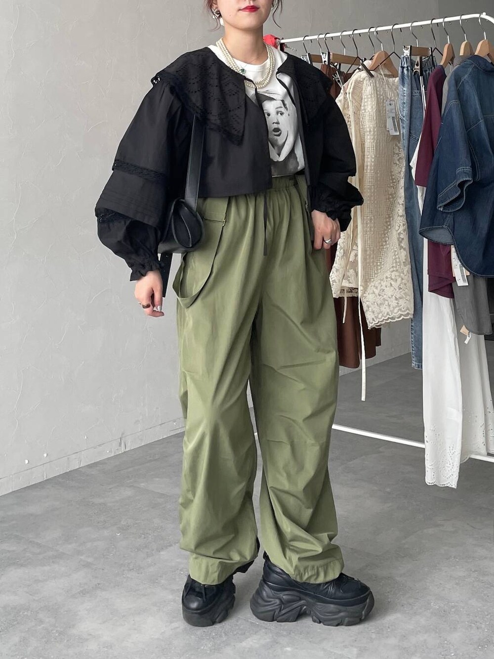 ブラック系のスニーカー、グリーン系のカーゴパンツ、ブラック系のショルダーバッグを着用したレディースの春コーディネートの3枚目の写真