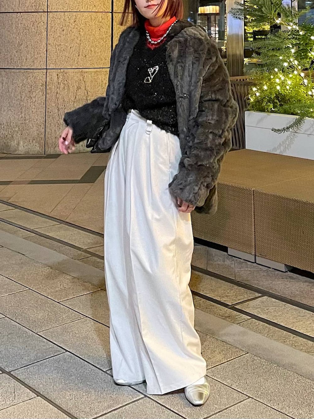 グレー系のブルゾン、ブラック系のニット/セーター、ベージュ系のスラックスを着用したレディースの冬コーディネートの3枚目の写真