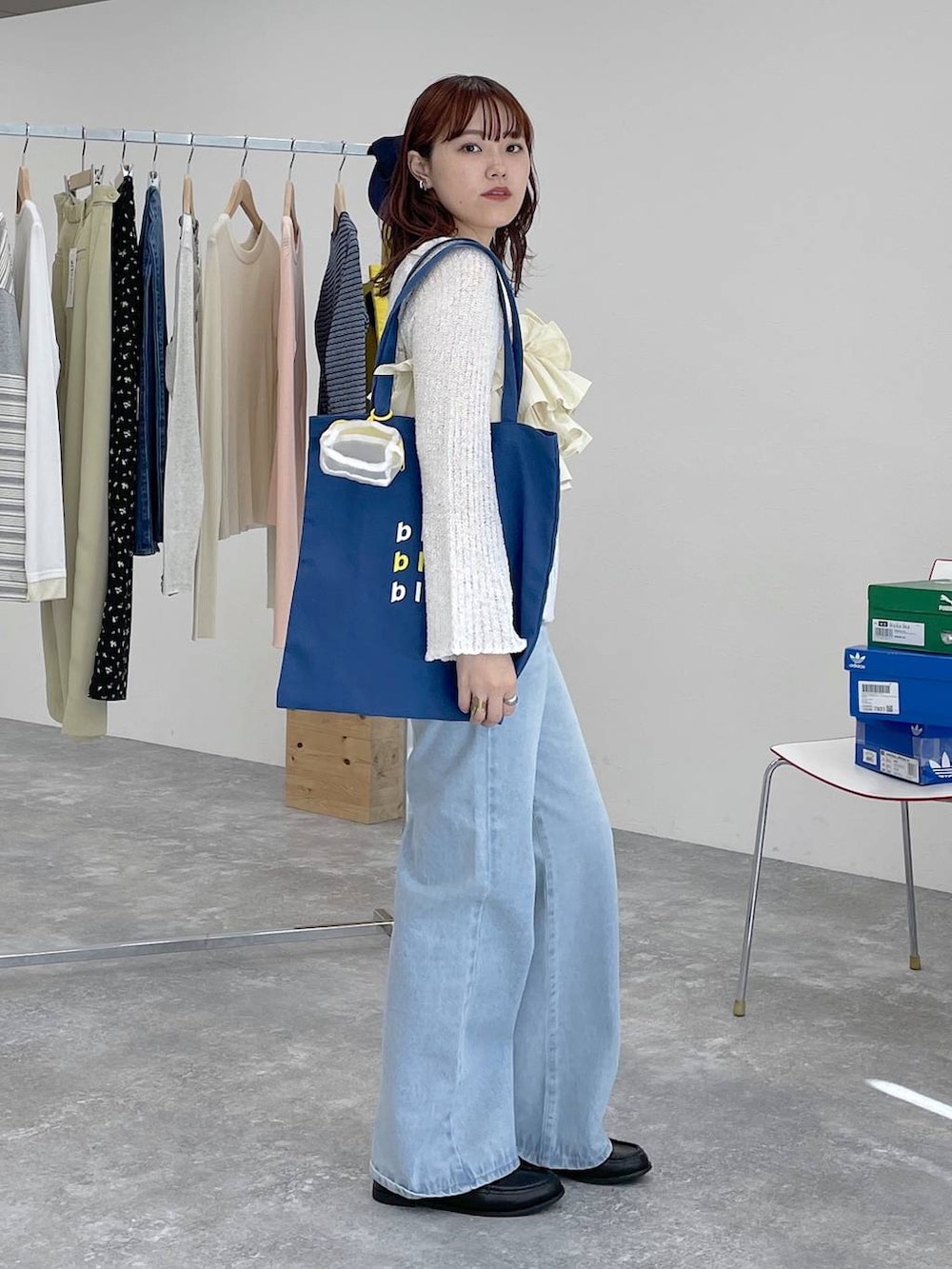 ブラック系のローファー、ブルー系のトートバッグ、ブルー系のデニムパンツを着用したレディースの春コーディネートの3枚目の写真