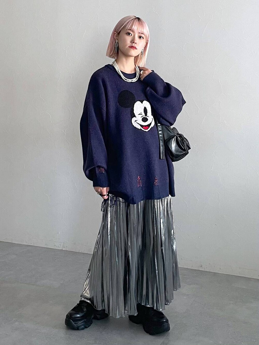 ブラック系のブーツ、ブラック系のショルダーバッグ、グレー系のスカートを着用したレディースの秋コーディネートの3枚目の写真