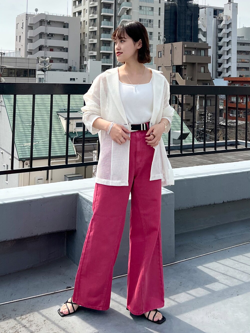 ピンク系のデニムパンツ、ホワイト系のテーラードジャケット、ホワイト系のタンクトップを着用したレディースの春コーディネートの3枚目の写真