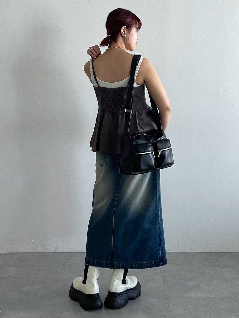 ブラック系のショルダーバッグ、ホワイト系のブーツ、ブルー系のスカートを着用したレディースの秋コーディネートの4枚目の写真