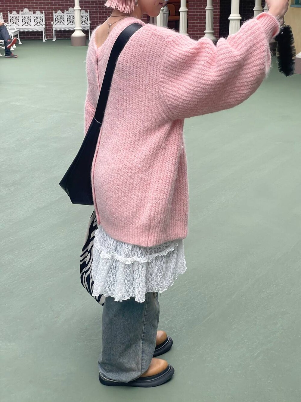 ブルー系のデニムパンツ、ブラック系のボディバッグ/ウエストポーチ、イエロー系のブーツを着用したレディースの秋コーディネートの6枚目の写真