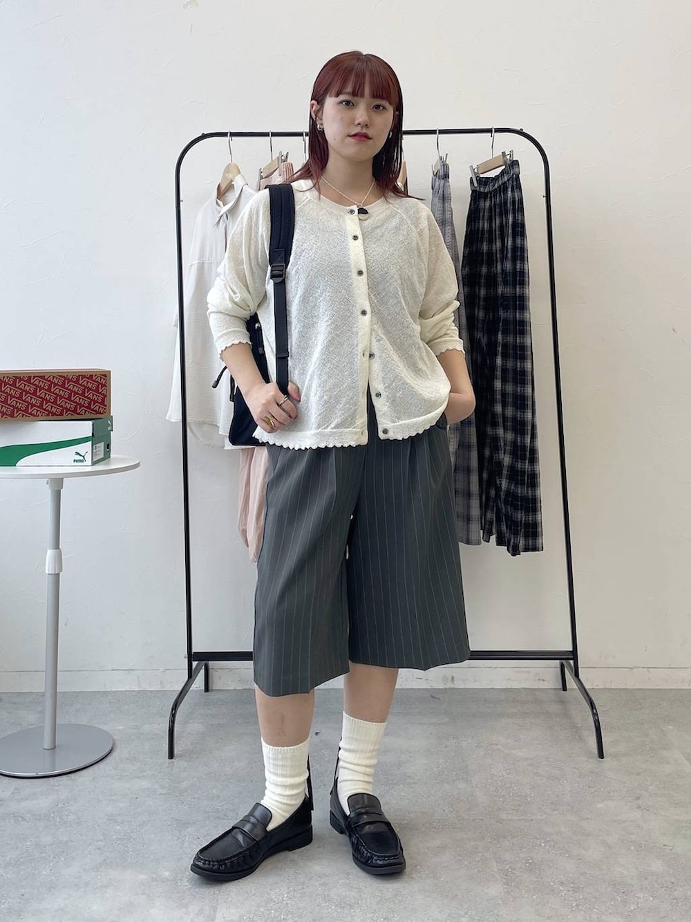 ブラック系のローファー、ブラック系のバックパック/リュック、グレー系のスラックスを着用したレディースの春コーディネートの2枚目の写真