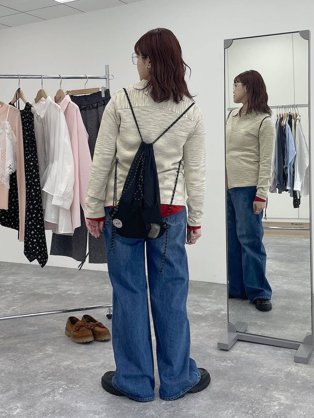 ブルー系のデニムパンツ、ホワイト系のカーディガン/ボレロを着用したレディースの冬コーディネートの2枚目の写真