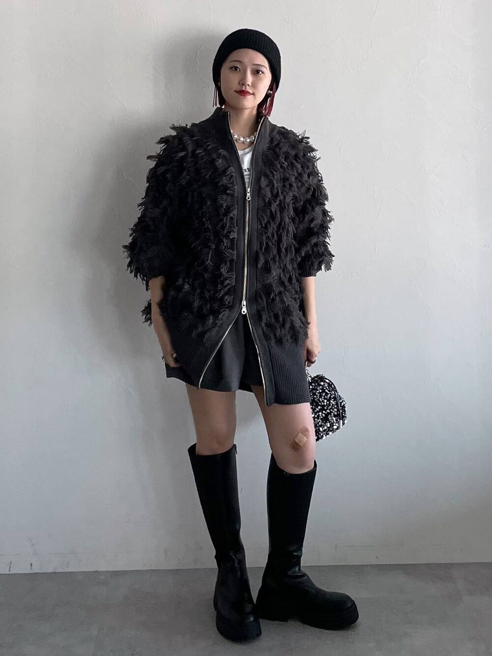 ブラック系のブーツ、グレー系のその他パンツ、シルバー系のショルダーバッグを着用したレディースの秋コーディネートの5枚目の写真