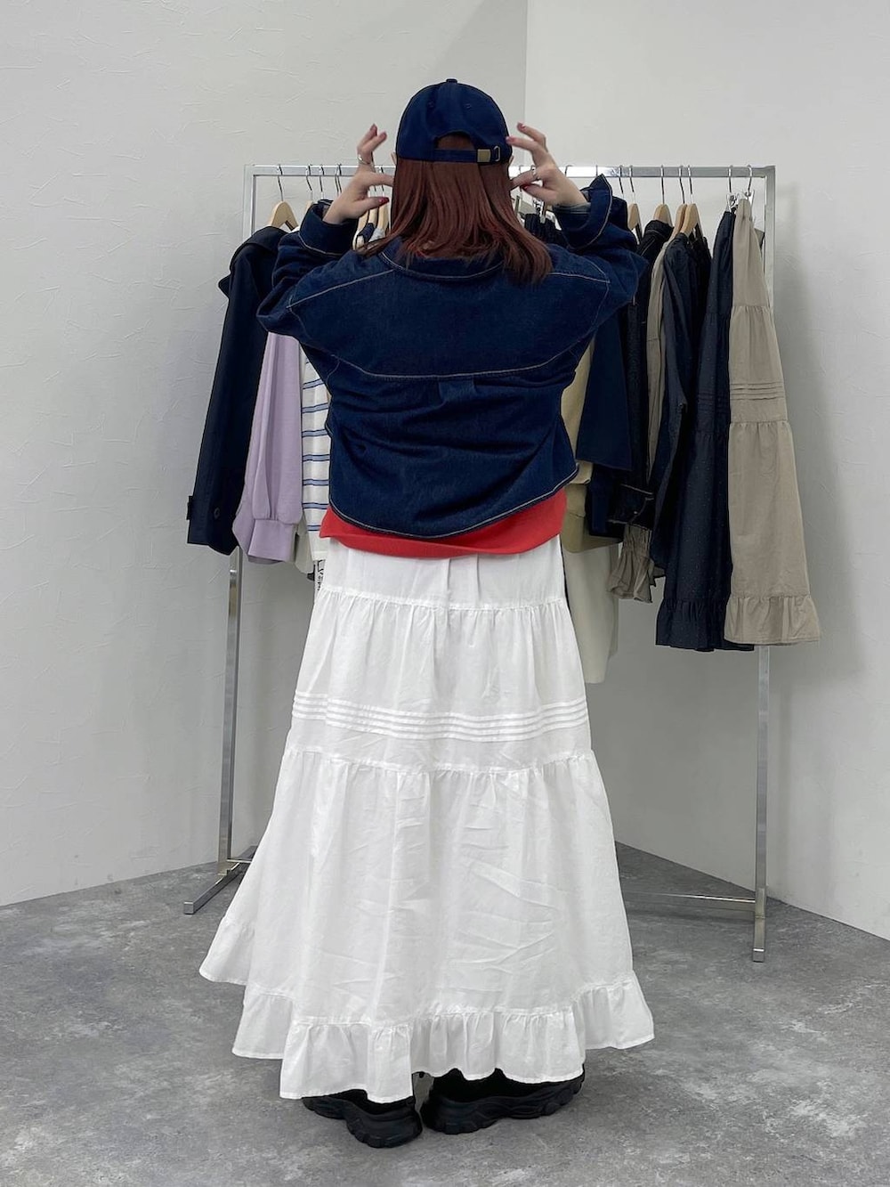 ブラック系のスニーカー、レッド系のスウェット、ホワイト系のスカートを着用したレディースの春コーディネートの4枚目の写真