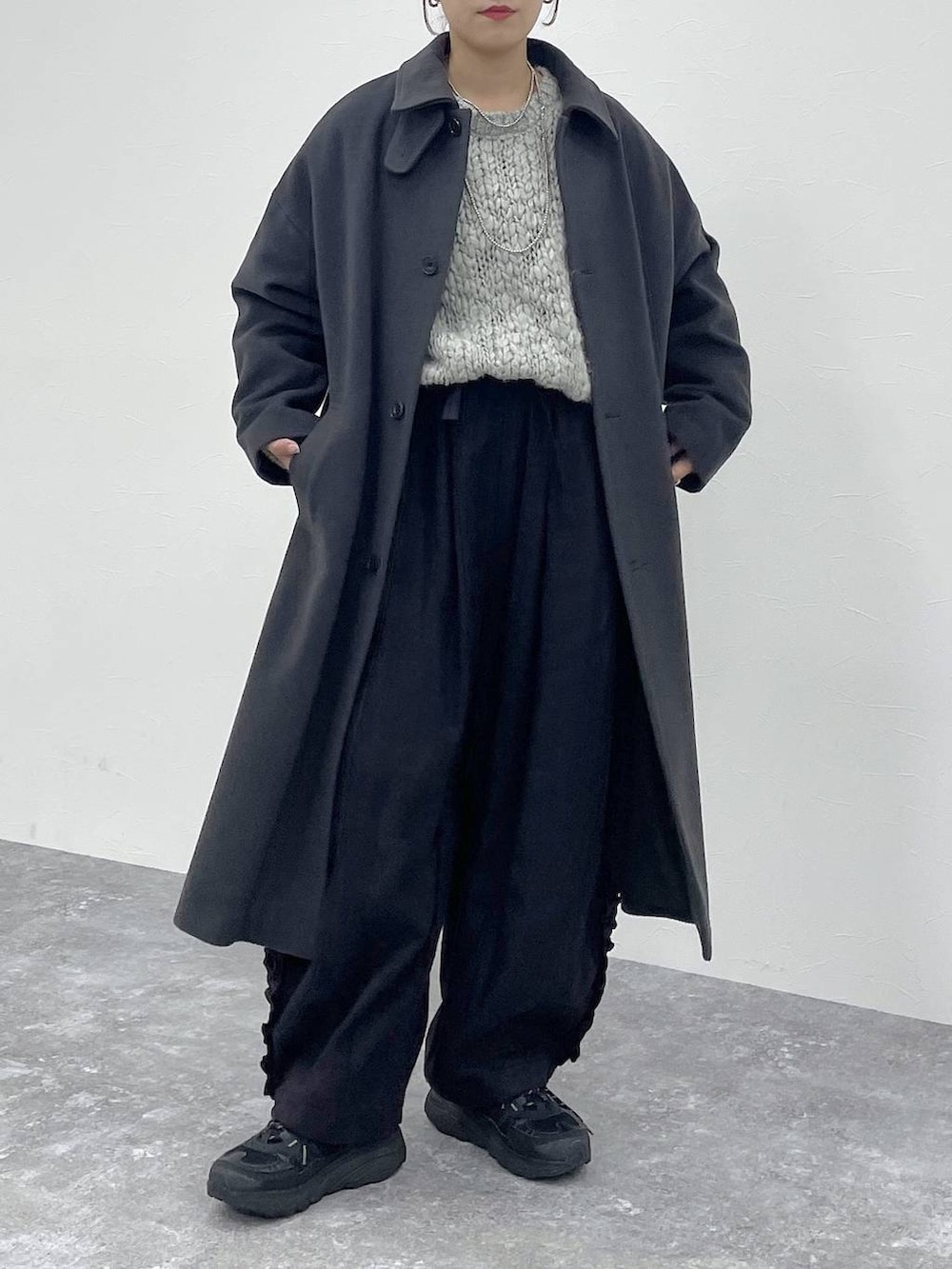 グレー系のニット/セーター、ブラック系のその他パンツを着用したレディースの秋コーディネートの5枚目の写真