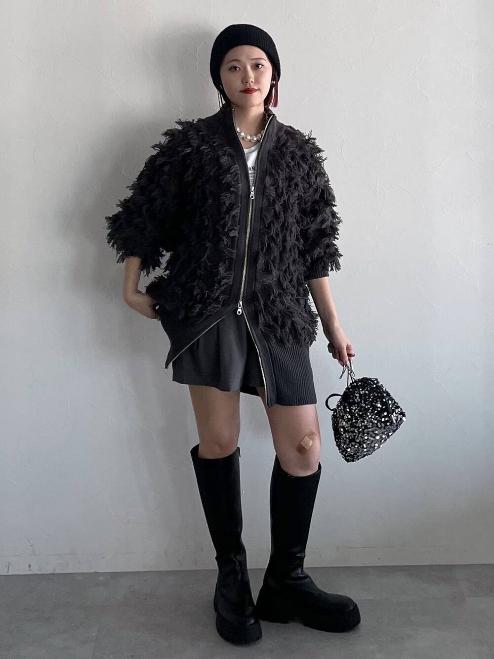 ブラック系のブーツ、グレー系のその他パンツ、シルバー系のショルダーバッグを着用したレディースの秋コーディネートの3枚目の写真