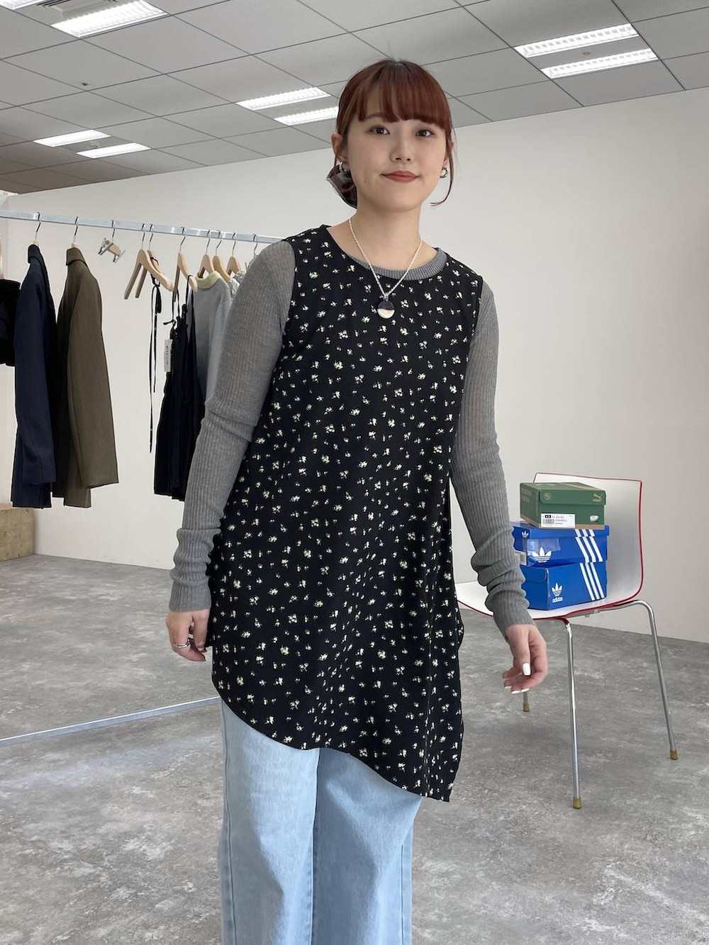 グレー系のニット/セーター、ブルー系のデニムパンツを着用したレディースの春コーディネートの2枚目の写真