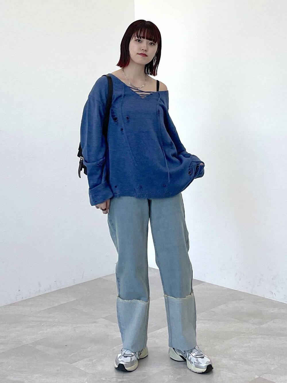 ブラック系のショルダーバッグ、ブルー系のニット/セーター、ブルー系のデニムパンツを着用したレディースの春コーディネートの8枚目の写真