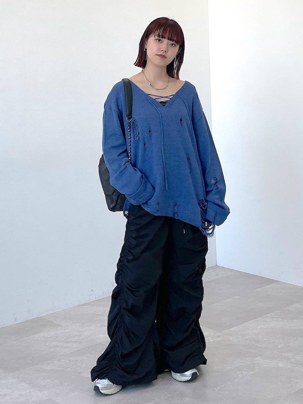 ブラック系のショルダーバッグ、ブルー系のニット/セーター、ブラック系のその他パンツを着用したレディースの冬コーディネートの6枚目の写真