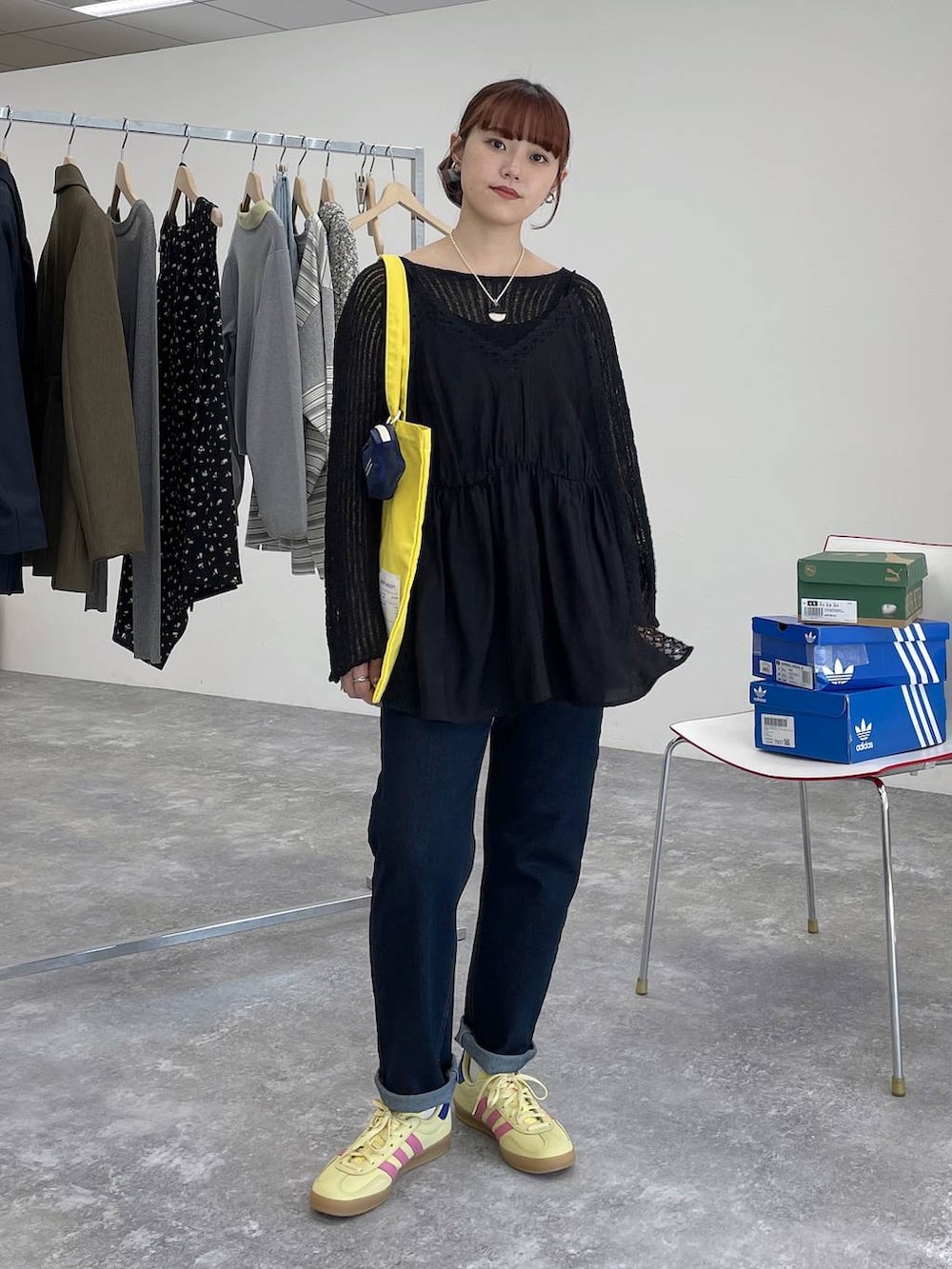 イエロー系のトートバッグ、ブルー系のデニムパンツ、ブラック系のキャミソールを着用したレディースの春コーディネートの2枚目の写真