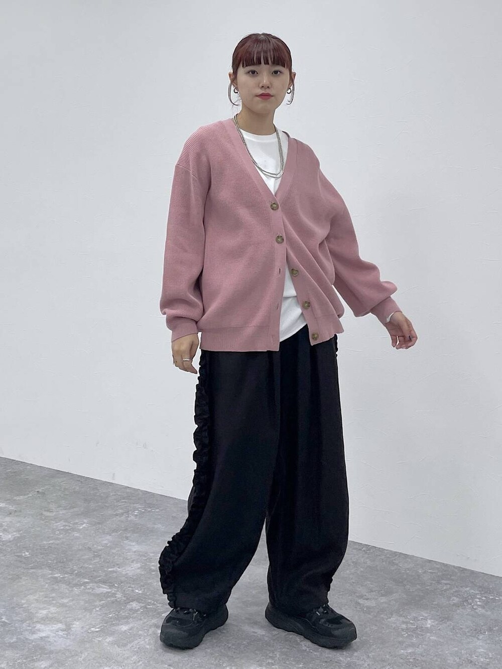 ホワイト系のTシャツ/カットソー、ピンク系のカーディガン/ボレロ、ブラック系のその他パンツを着用したレディースの秋コーディネートの2枚目の写真