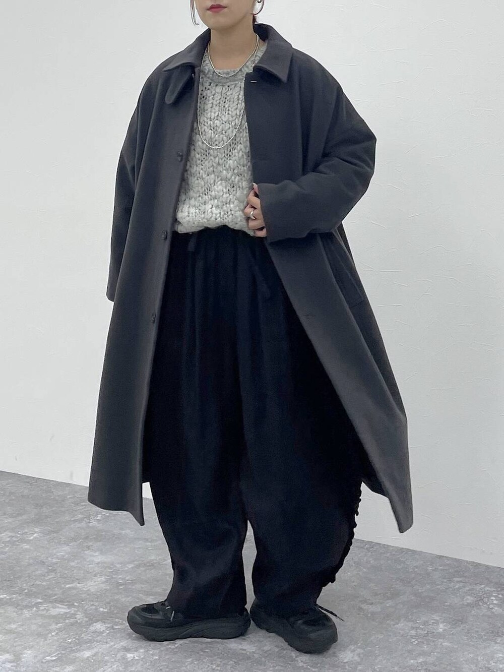 グレー系のニット/セーター、ブラック系のその他パンツを着用したレディースの秋コーディネートの6枚目の写真