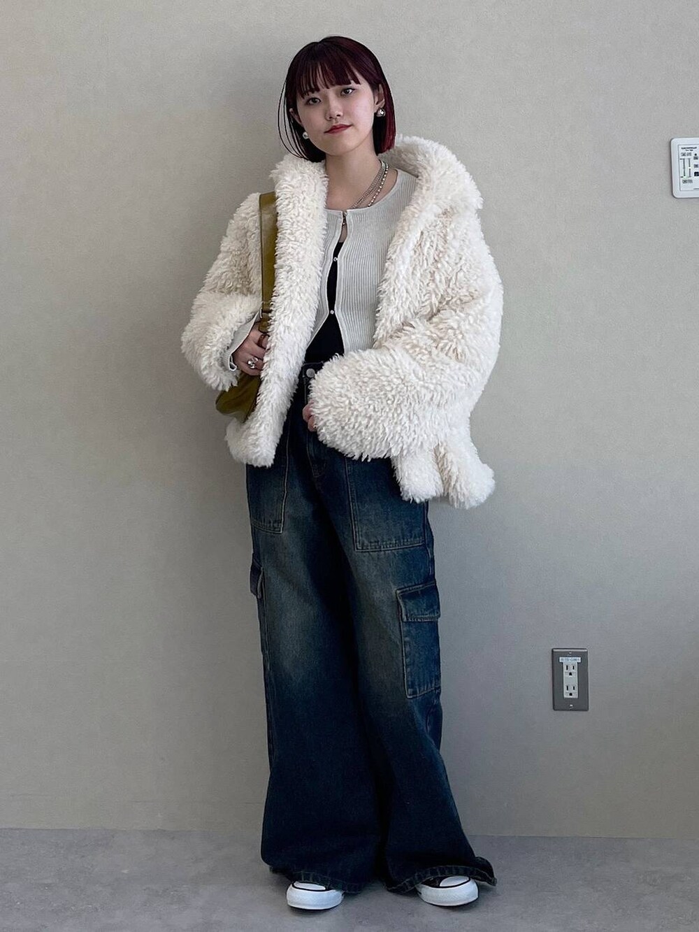 イエロー系のショルダーバッグ、ブルー系のデニムパンツ、ホワイト系のその他アウターを着用したレディースの冬コーディネートの8枚目の写真