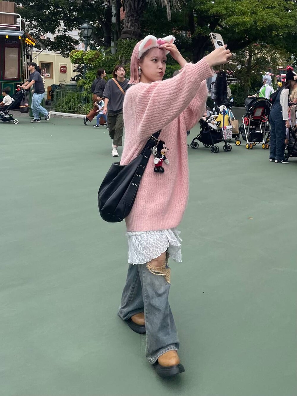 ブルー系のデニムパンツ、ブラック系のボディバッグ/ウエストポーチ、イエロー系のブーツを着用したレディースの秋コーディネートの4枚目の写真