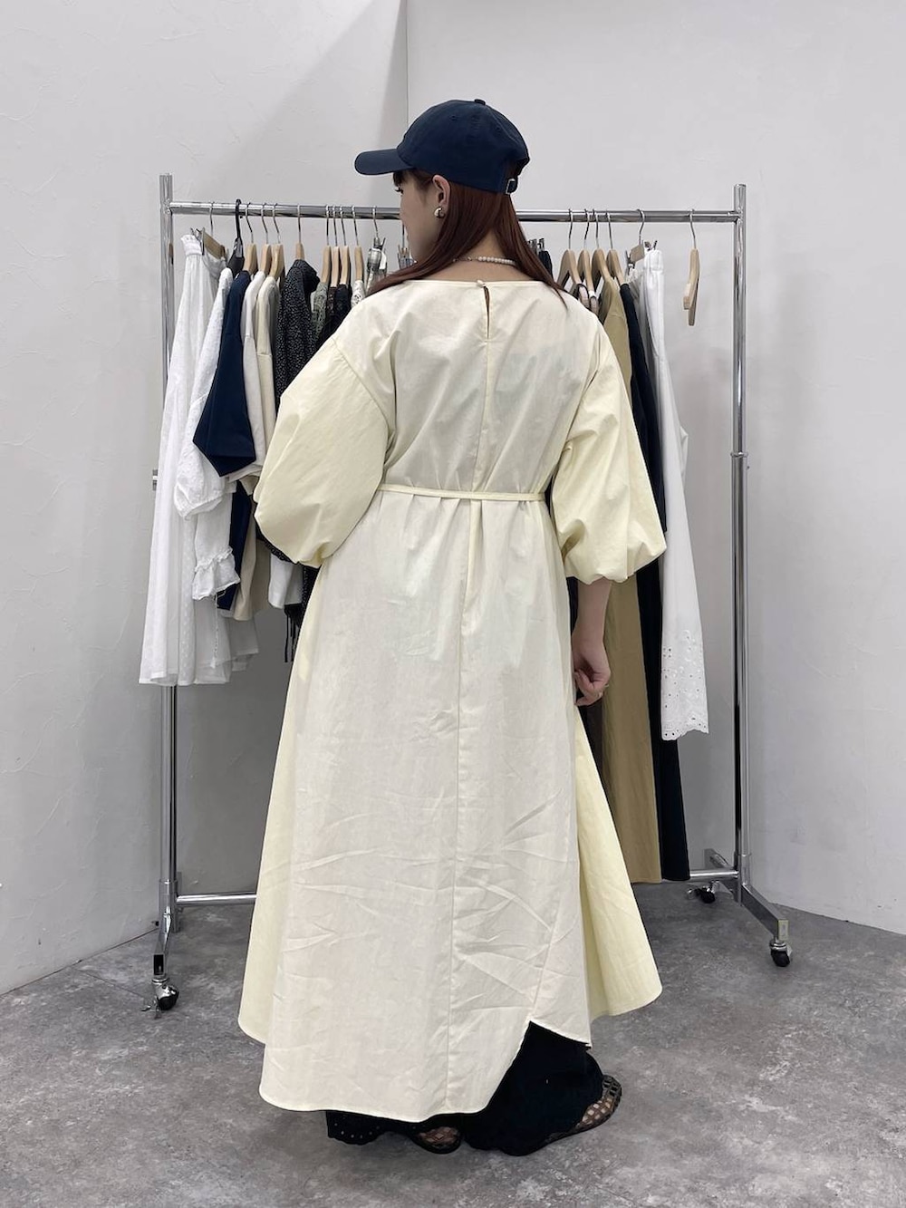 ブラック系のパンプス、ブラック系のデニムパンツ、ベージュ系のワンピースを着用したレディースの夏コーディネートの4枚目の写真