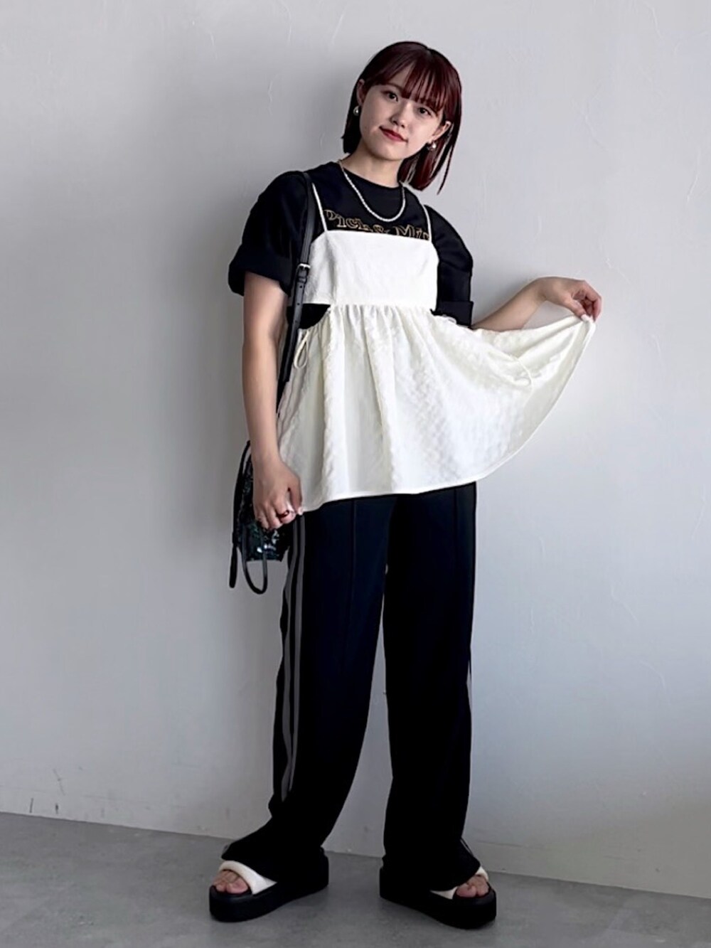 ホワイト系のキャミソール、ブラック系のスウェットパンツ、ブラック系のTシャツ/カットソーを着用したレディースの夏コーディネートの3枚目の写真