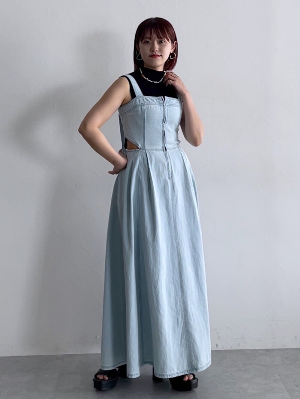 ブラック系のトップス、ブルー系のジャンパースカート、ブラック系のシューズを着用したレディースの春コーディネートの7枚目の写真