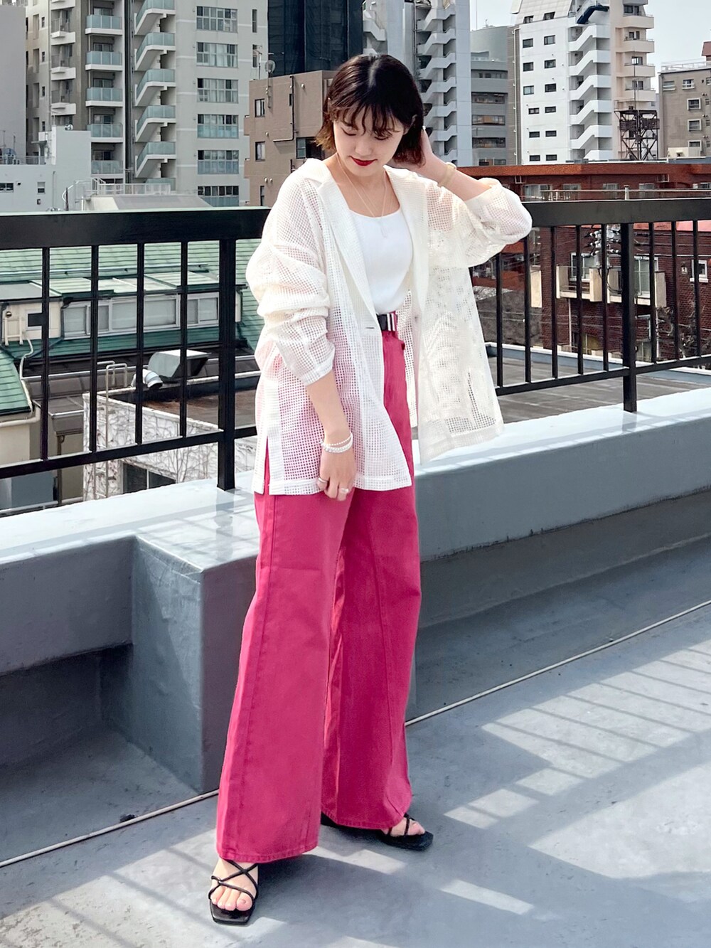 ピンク系のデニムパンツ、ホワイト系のテーラードジャケット、ホワイト系のタンクトップを着用したレディースの春コーディネートの2枚目の写真