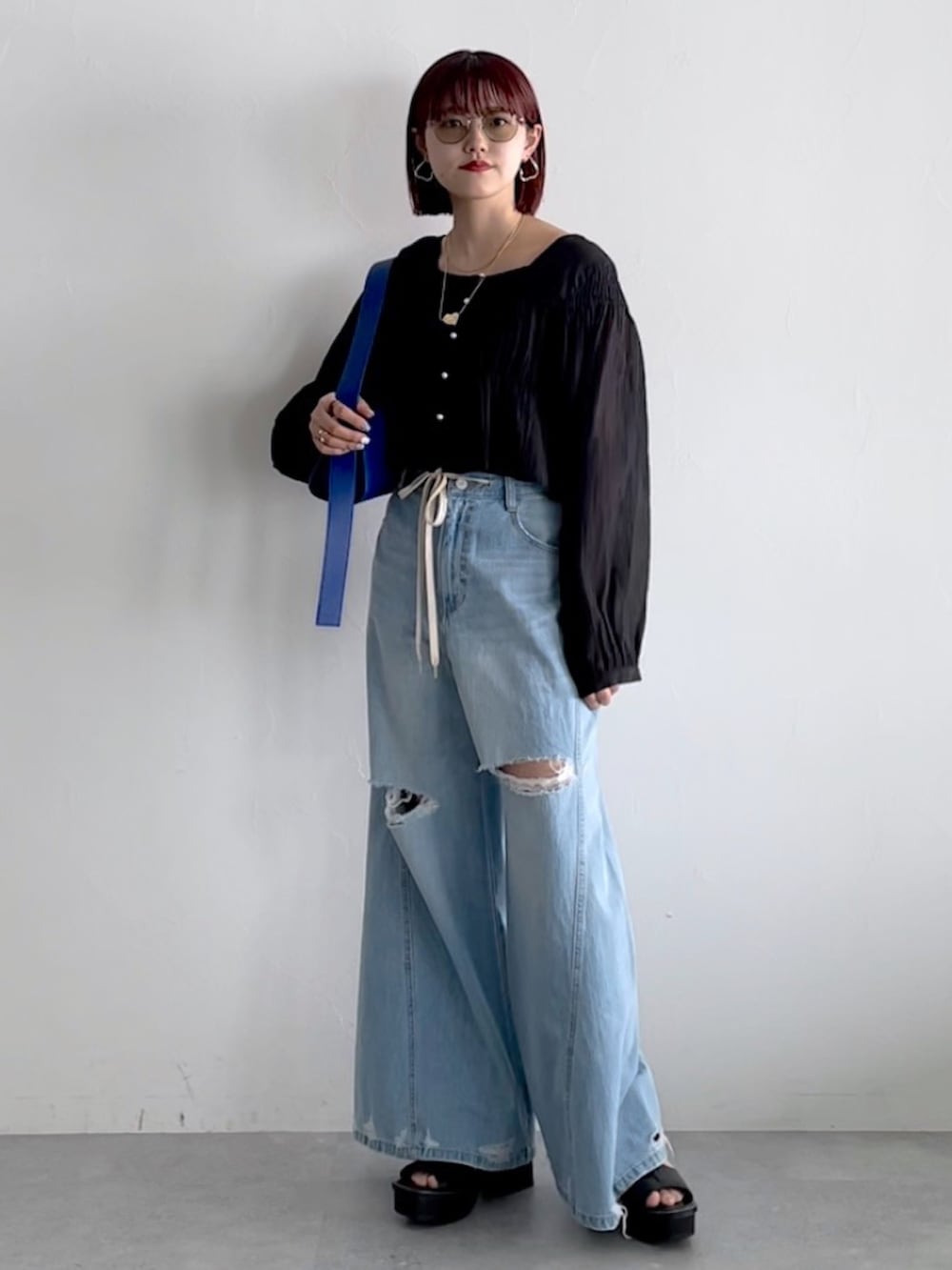 ブルー系のデニムパンツ、ブラック系のシューズ、ブラック系のシャツ/ブラウスを着用したレディースの春コーディネートの5枚目の写真