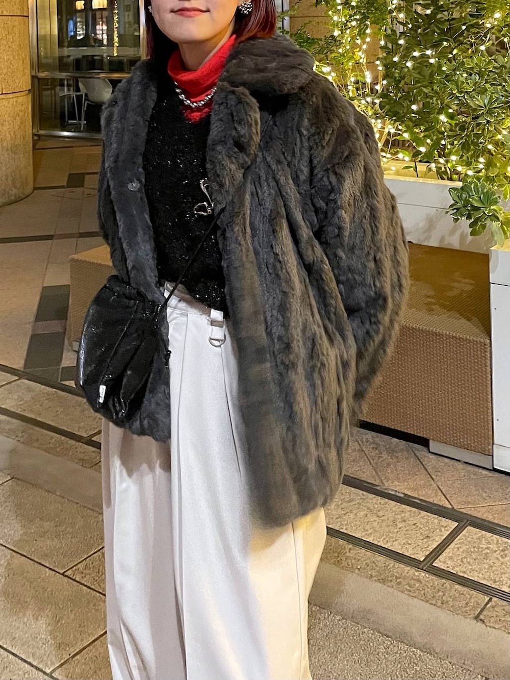 グレー系のブルゾン、ブラック系のニット/セーター、ベージュ系のスラックスを着用したレディースの冬コーディネートの6枚目の写真