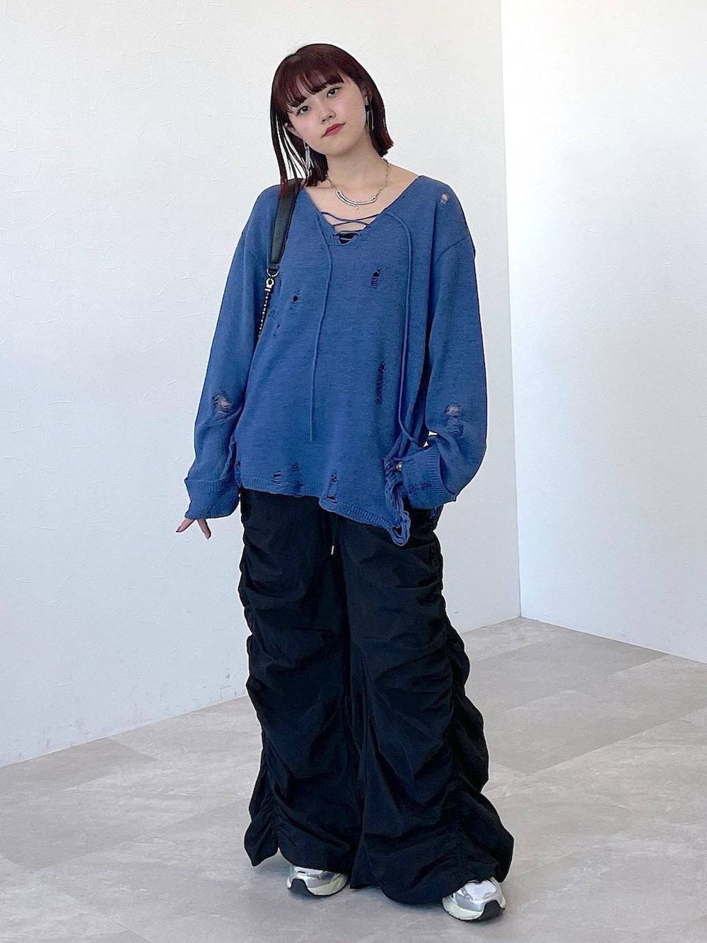 ブラック系のショルダーバッグ、ブルー系のニット/セーター、ブラック系のその他パンツを着用したレディースの冬コーディネートの7枚目の写真